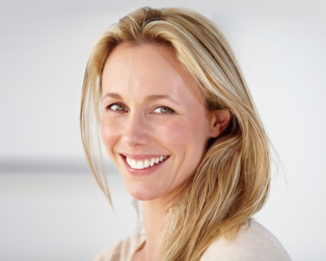 Professional headshot of a smiling woman with blonde hair against a neutral white background.
